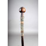 A Zulu knobkerrie, with spherical head and remains of wire binding, with a faceted tip, 84cm long.