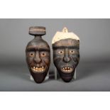 Two Greenland house masks; one with raised coiffure, incised scarifications and with inset bone