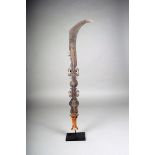 A Konda iron currency knife, D.R.Congo, shaped and engraved motifs with a wood handle, 64cm high, on