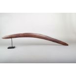 An Aboriginal boomerang, of slender curved form with incised linear decoration to the front with