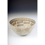 A Mimbres black on white bowl, the interior decorated with a linear band with rectangular drops, the