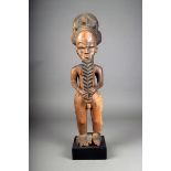 A Baule standing male figure, Ivory Coast, with elaborate linear decorated coiffure, face and body