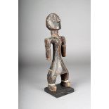 A Bagirimi standing figure, Chad, with body scarifications and aluminium ankle bindings, 34cm
