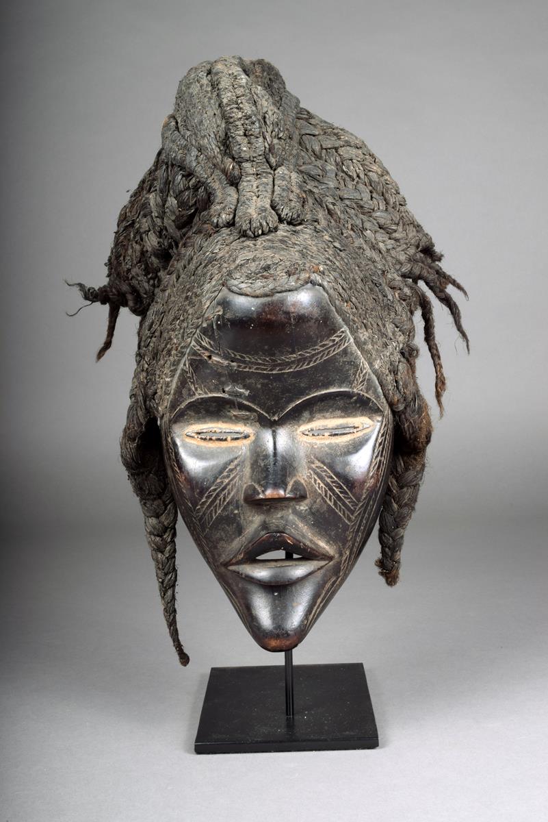 A Dan mask, Ivory Coast, with pronounced lips and scarifications,  slit eyes with kaolin, with an