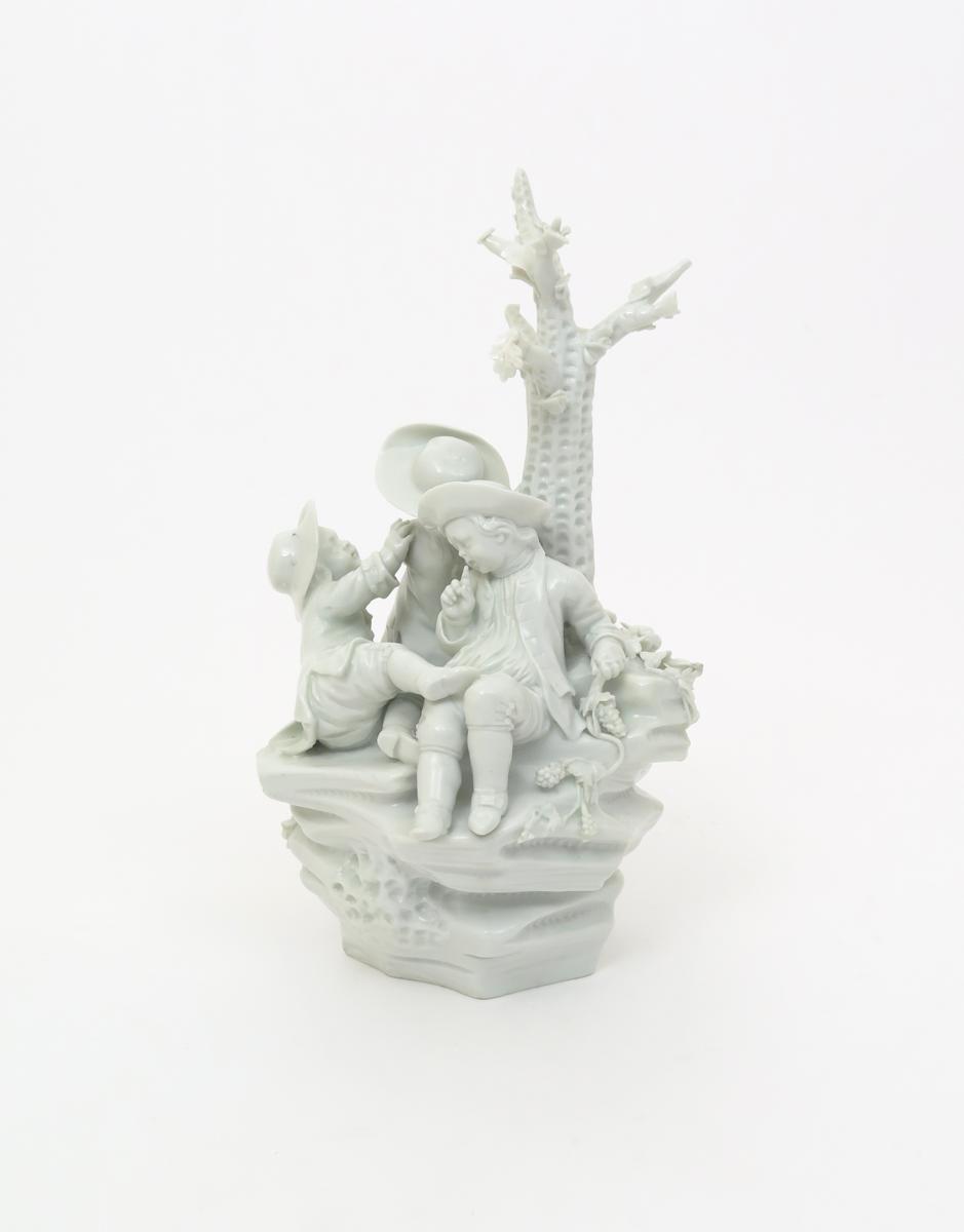 A Tournai white-glazed figure group  c.1770, modelled with three boys playing beneath a tree on a