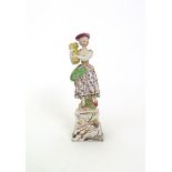 A Continental faïence figure of Summer  late 18th century, modelled as a lady holding a sheaf of