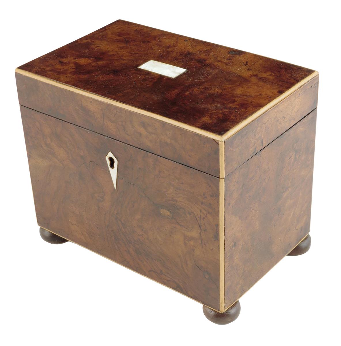 A walnut tea caddy, with boxwood stringing, the interior with a single lidded compartment, on disc