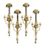 A set of four French twin light wall appliques, each with a palm tree backplate above a seated