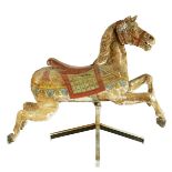 A late 19th century carved wood and polychrome decorated fairground horse, with glass eyes, on a