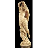 λ A 19th century French Dieppe ivory carving of Venus and Cupid, on a flower strewn base, 18.3cm