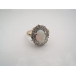 An opal and diamond ring, centred with an oval cabochon opal weighing approximately 0.84cts, the