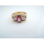 A tourmaline and diamond ring, Roy Morris, centred with an oval mixed-cut untested pink tourmaline