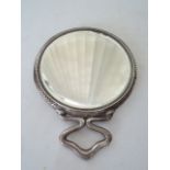 An Edwardian silver mirror, Henry Matthews, Birmingham, 1903, the circular body with hammered