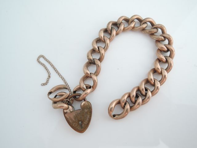 A 9ct rose gold curb-link bracelet, with gold-plated heart-shaped padlock clasp, and two loose