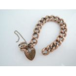 A 9ct rose gold curb-link bracelet, with gold-plated heart-shaped padlock clasp, and two loose