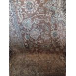 A Persian style wool carpet in tones of beige, the central medallion surrounded by floral detail,