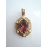 A tourmaline and pearl pendant clasp, centred with an oval mixed-cut untested pink tourmaline