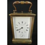 An English brass carriage clock with enamel dial and 8 day striking movement and alarm, the gong