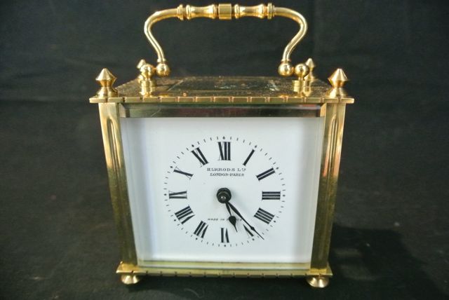 A French brass carriage clock, the case of square outline with enamel dial and 8 day timepiece