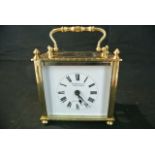 A French brass carriage clock, the case of square outline with enamel dial and 8 day timepiece