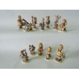 A collection of twelve Hummel figure groups including a little boy looking through a telescope, a