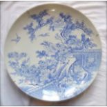 A large oriental blue and white charger with painted decoration incorporating prunus tree,