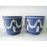 A pair of large Wedgwood dark blue ground Jasperware jardinières with fruiting vine swag, lion