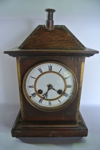 A late 19th century oak cottage mantle clock, the case in the form of a small house with chimney pot