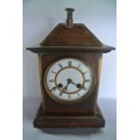 A late 19th century oak cottage mantle clock, the case in the form of a small house with chimney pot
