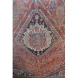 Three various old Persian rugs, the largest with lozenge shaped medallion centre upon a red field,