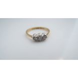 A three-stone diamond ring, set with two round brilliant-diamonds and one single-cut diamond, in
