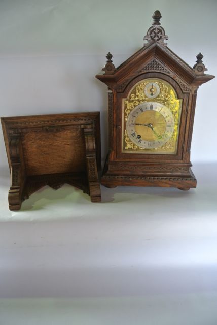 A small 19th century oak bracket clock and bracket, the architectural case with carved detail