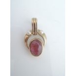 A ruby and pearl pendant clasp, set with an untested cabochon ruby, highlighted above with two