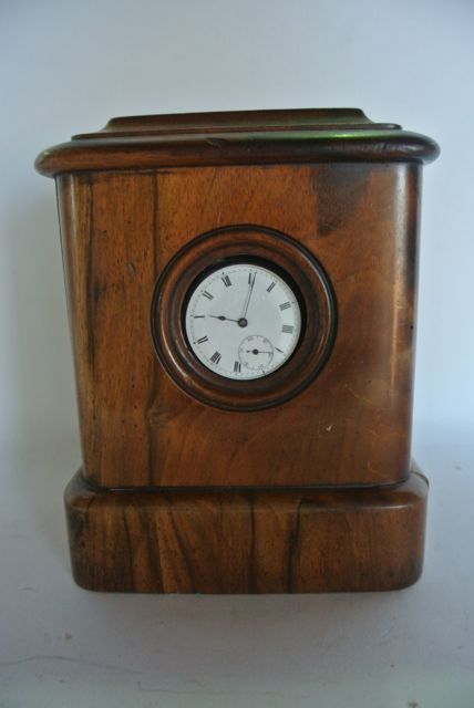 A collection of five watch holders including a mahogany example of shield shape to support three