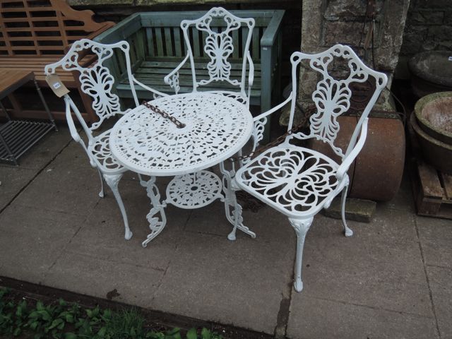 A decorative cast aluminium terrace table of circular form with decorative pierced circular