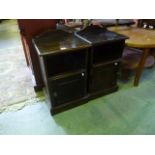 A pair of contemporary stained pine bedside cupboards each enclosed by a panelled door beneath