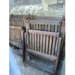 A set of four contemporary hardwood folding garden armchairs with slatted seats