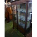 An Edwardian mahogany freestanding display cabinet enclosed by a pair of partially glazed panelled