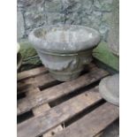 A weathered composition stone garden urn of circular tapered form with raised relief classical