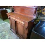 A Victorian mahogany chiffonier, the raised back with shaped and moulded outline and simple