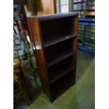 A small oak freestanding open bookcase with three fixed shelves and split moulded surround