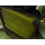 A vintage green canvas and leather re-inforced suitcase together with a wicker clothes basket and