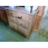 An Edwardian stripped pine bedroom chest of three long drawers with moulded plinth