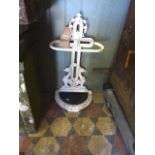 A Victorian cast iron umbrella stand with face mask, entwined griffin and further decorative