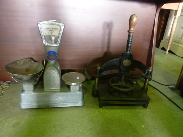A small 19th century cast iron and brass press with turned wooden handle, and an oval plaque