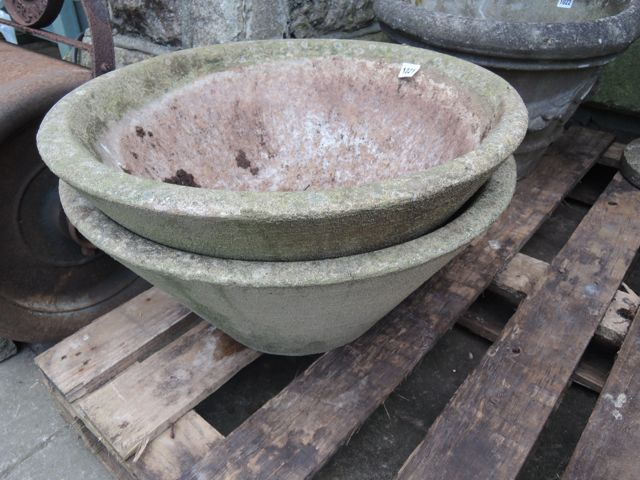 A pair of weathered cast composition stone garden planters of circular tapered form