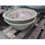 A pair of weathered cast composition stone garden planters of circular tapered form