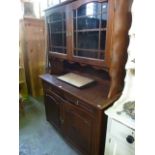 A contemporary oak kitchen dresser, the lower section enclosed by a pair of fielded arched