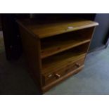 A low contemporary pine unit with open shelves over a long drawer to base