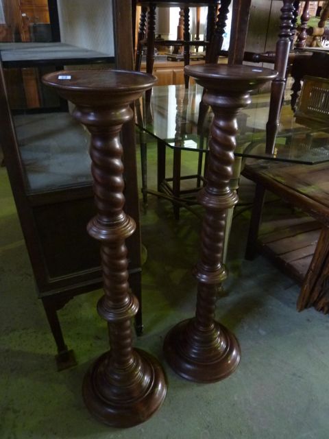 A pair of contemporary stained beechwood torcheres with rope twist and ring columns raised on